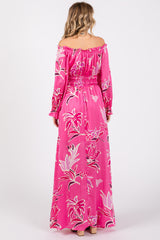 woman wearing a pink off-shoulder maxi dress with floral print and long sleeves, showing the back view