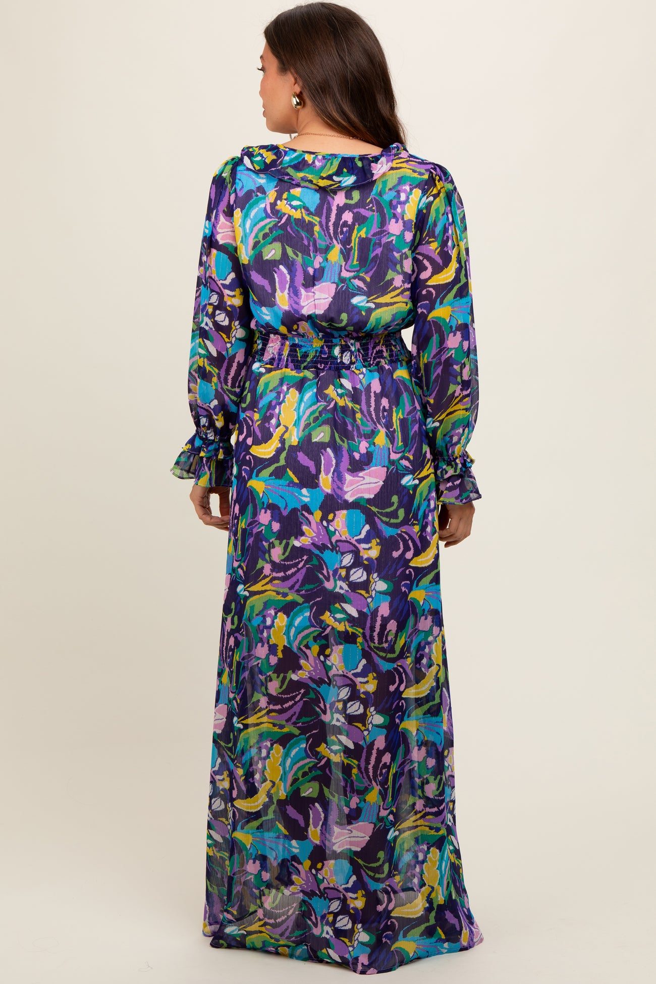 woman wearing a colorful floral print maternity maxi dress with long sleeves and a cinched waist, showing off her baby bump