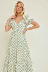 woman wearing a green floral puff sleeve maxi dress with a v-neck and tiered skirt
