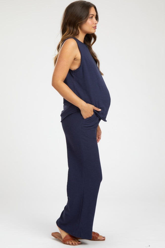 woman wearing a navy maternity tank top and matching skirt, showing her baby bump from the side