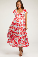woman wearing a red and light blue floral maternity maxi dress with ruffled sleeves and a tiered hem, showcasing her baby bump