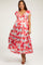 woman wearing a red and light blue floral maternity maxi dress with ruffled sleeves and a tiered hem, showcasing her baby bump