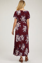 woman wearing a maroon floral maternity maxi dress with short sleeves and a tie waist from the back