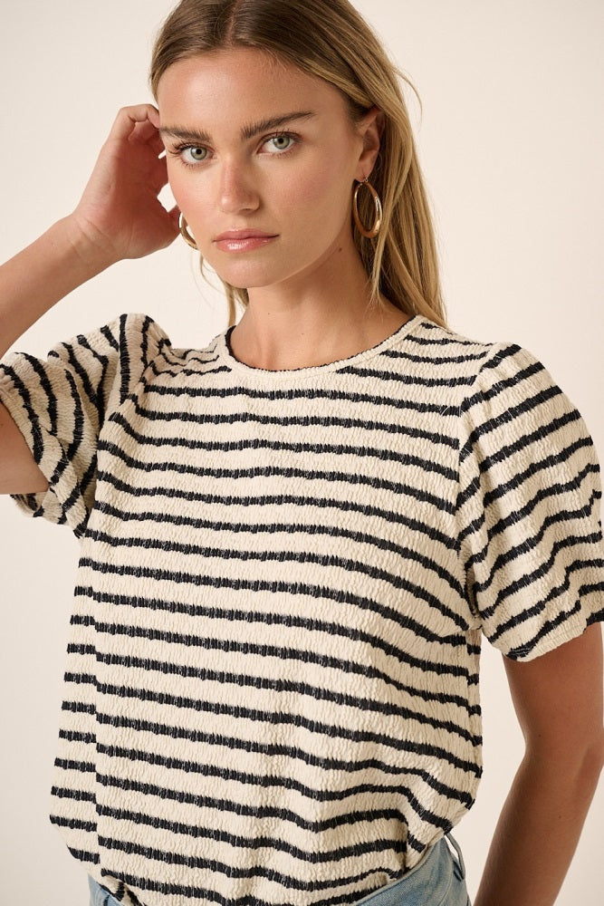 woman wearing a cream and navy striped short sleeve top with puffed sleeves