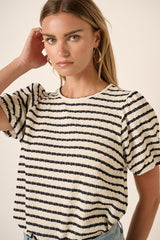 woman wearing a cream and navy striped short sleeve top with puffed sleeves