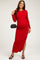 woman wearing a red ribbed maternity maxi dress with long sleeves and a side slit, holding a black handbag and showing her baby bump