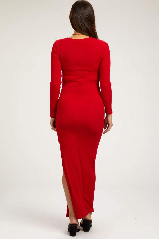 woman wearing a red ribbed maternity maxi dress with long sleeves and a thigh-high slit