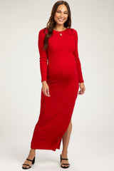 woman wearing a red ribbed maternity maxi dress with long sleeves and a side slit, showing off her baby bump