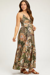 woman wearing a flowy floral print maternity maxi dress with a wrap style and adjustable straps, displaying her baby bump