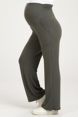 woman wearing dark gray maternity yoga pants with a fitted waist and wide legs, showing her baby bump