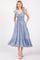 woman wearing a light blue maxi dress with flutter sleeves and a cinched waist, styled with pockets