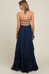 woman wearing a navy blue maternity maxi dress with a halter neck and tiered ruffles