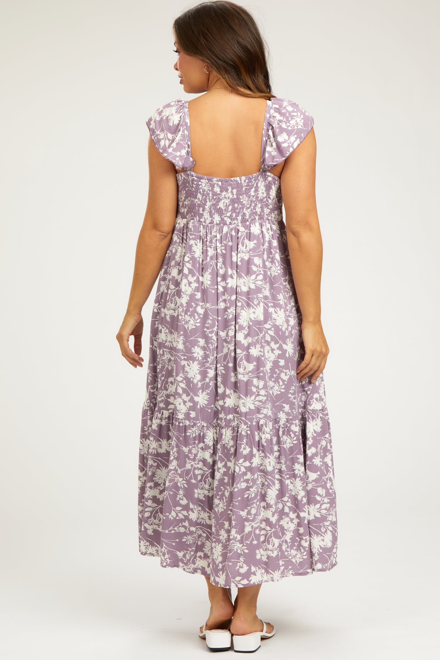 woman wearing a lavender floral maternity maxi dress with a smocked back and cap sleeves