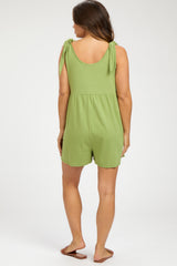 woman wearing a green maternity romper with tie straps and a relaxed fit, seen from the back