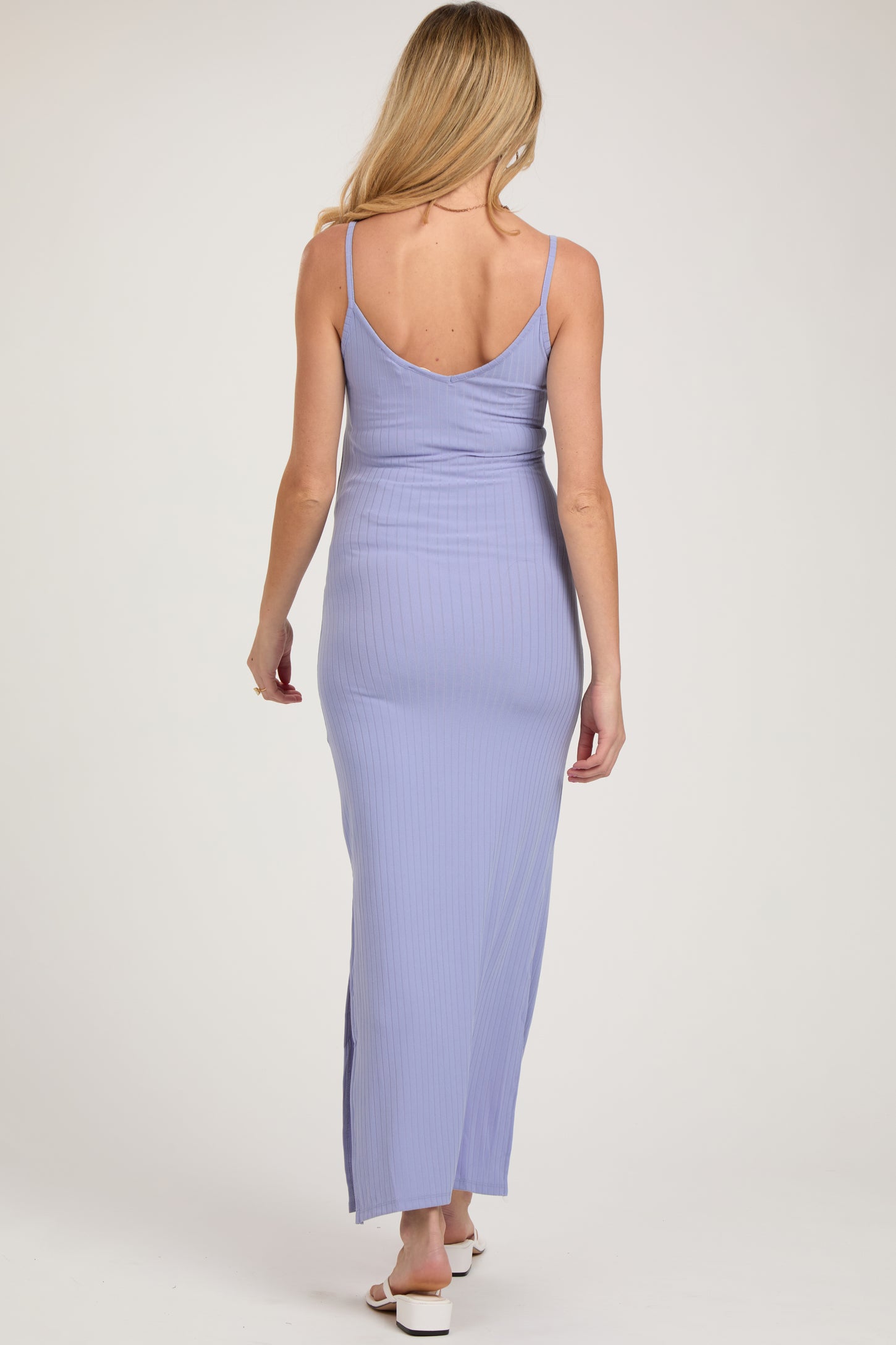 woman wearing a lavender ribbed maternity maxi dress with a form-fitting silhouette and a side slit