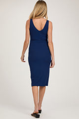 woman wearing a navy blue ribbed maternity dress with a V-back and midi length, showing her baby bump from the back
