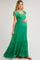 woman wearing a green maternity maxi dress with ruffle sleeves and a baby bump.