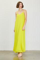 woman wearing a bright yellow maxi dress with thin straps and a flowing design