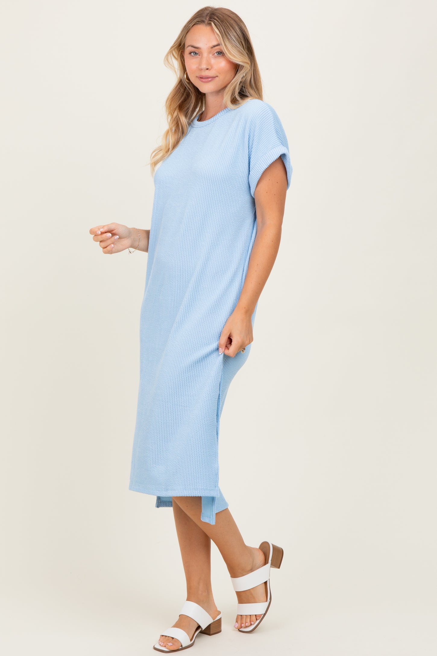woman wearing a light blue short sleeve ribbed maxi dress with side slits and brown block-heeled sandals
