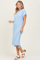 woman wearing a light blue short sleeve ribbed maxi dress with side slits and brown block-heeled sandals