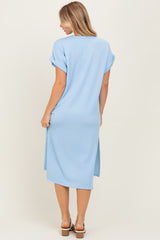 woman wearing a light blue ribbed midi dress with rolled sleeves and side slits, shown from the back