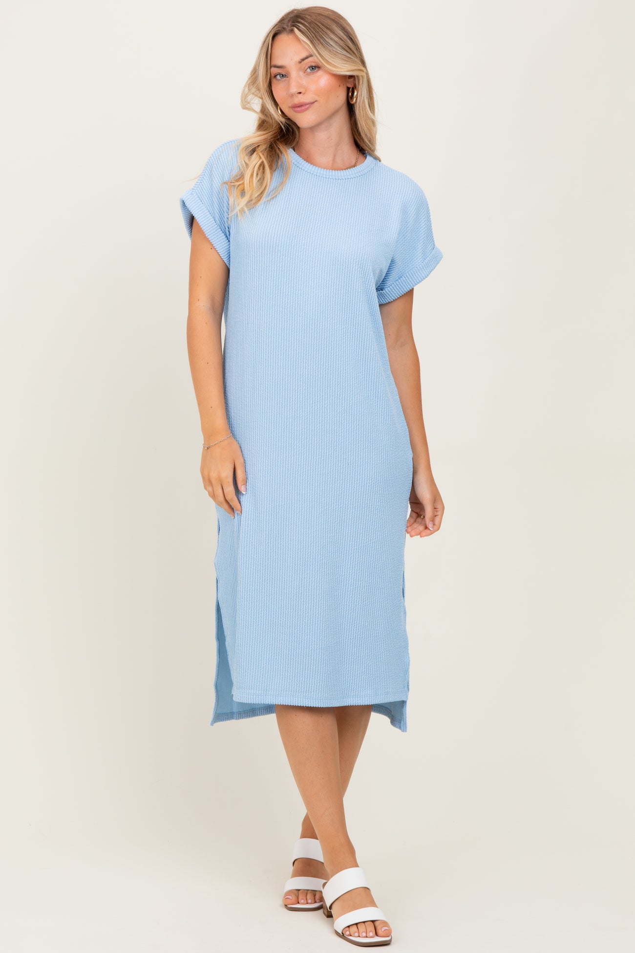 woman wearing a light blue relaxed fit ribbed midi dress with rolled sleeves and side slits
