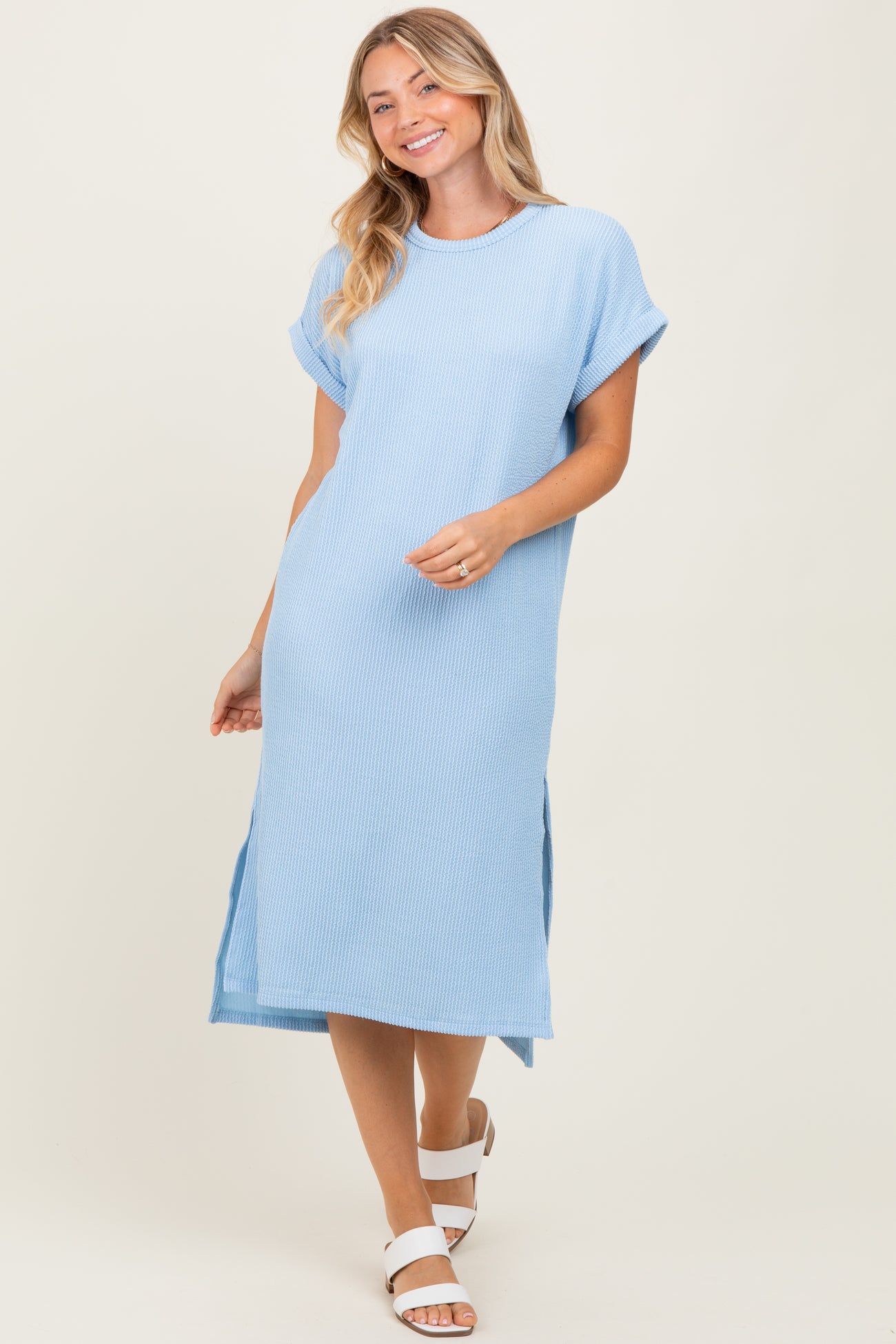 woman wearing a light blue ribbed midi dress with short sleeves and side slits