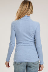 woman wearing a light blue long sleeve maternity top seen from the back