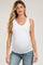 woman wearing a white maternity tank top and showing her baby bump while standing confidently