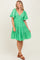 woman wearing a green gingham tiered dress with puff sleeves and a v-neckline