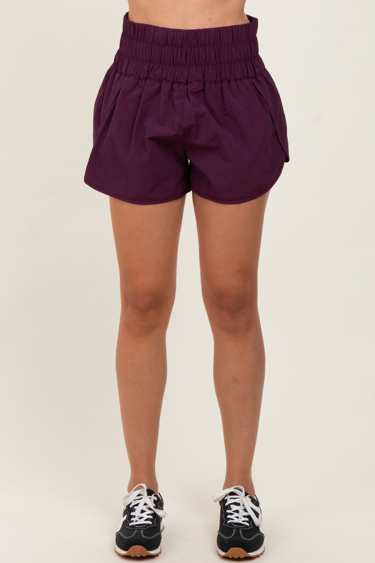woman wearing purple elastic waistband shorts with a relaxed fit and side pockets