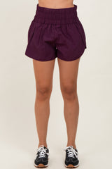 woman wearing purple elastic waistband shorts with a relaxed fit and side pockets
