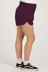 woman wearing purple maternity shorts with an elastic waistband and a visible baby bump