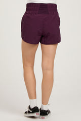 woman wearing purple maternity shorts, showing the back view with a comfortable elastic waistband