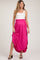 woman wearing a white tank top and a bright pink maxi maternity skirt with an elastic waistband