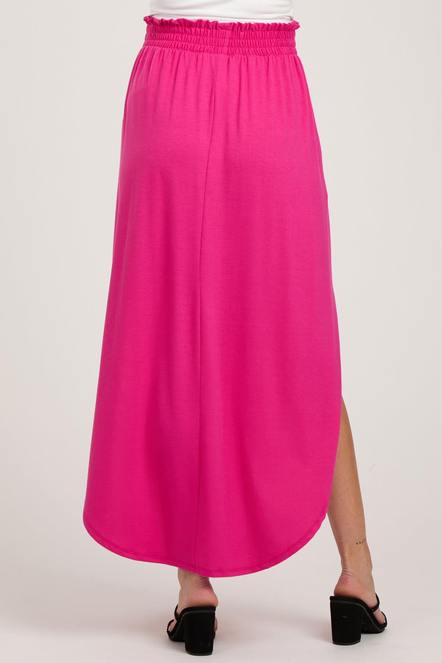 woman wearing a pink maternity maxi skirt with a stretchy waistband and a side slit