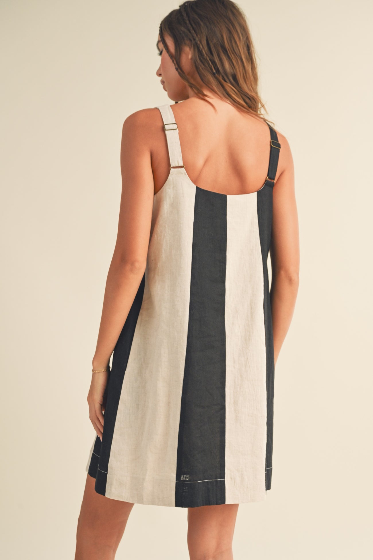 woman wearing a black and cream striped sleeveless dress with adjustable straps