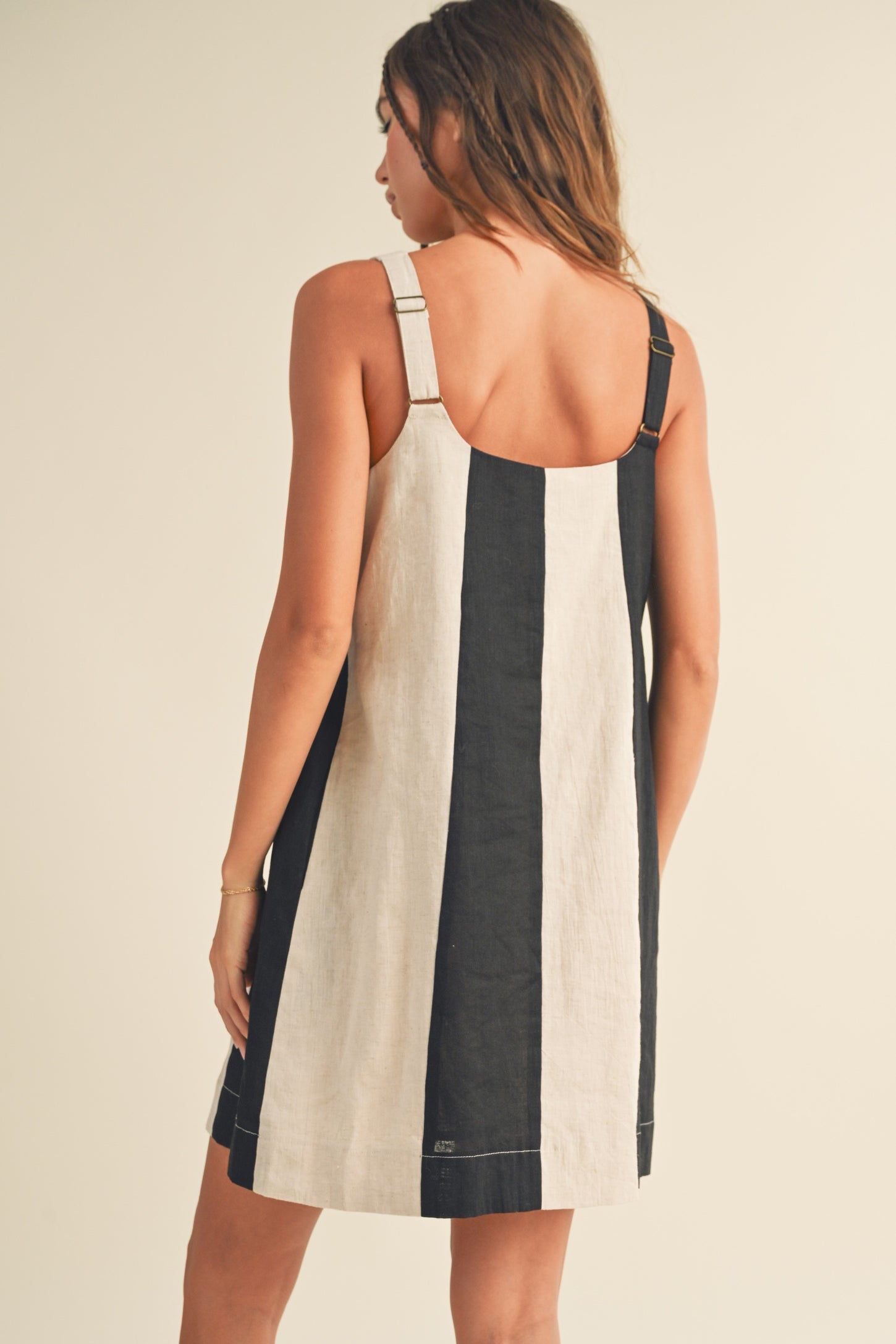 woman wearing a black and cream striped sleeveless dress with adjustable straps