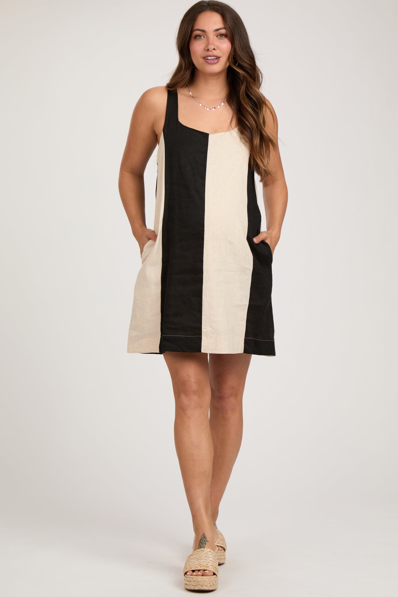 woman wearing a striped black and cream maternity dress with pockets and a casual fit