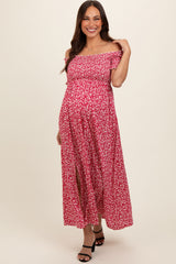 woman wearing a pink off-the-shoulder maternity maxi dress with floral print and side slits, showing her baby bump