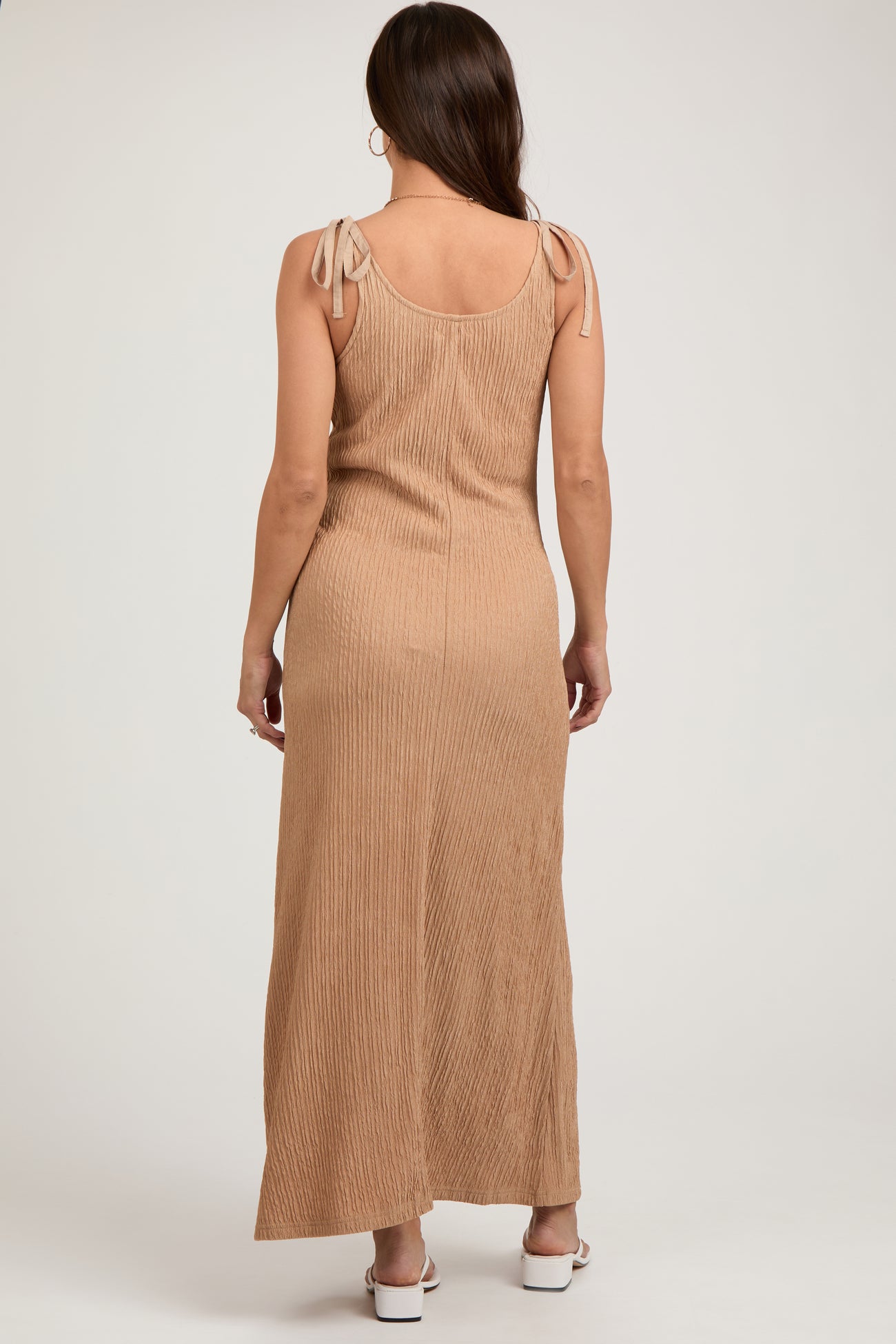woman wearing a tan ribbed maternity maxi dress with tie shoulder details and a visible baby bump