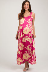 woman wearing a pink floral maternity maxi dress with adjustable straps and a flowing silhouette, showing her baby bump