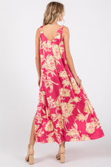 woman wearing a pink floral maxi dress with a low back and side slits, shown from the back