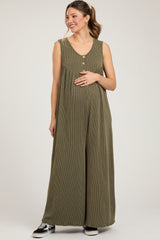 woman wearing a green striped maternity jumpsuit with buttons and a visible baby bump