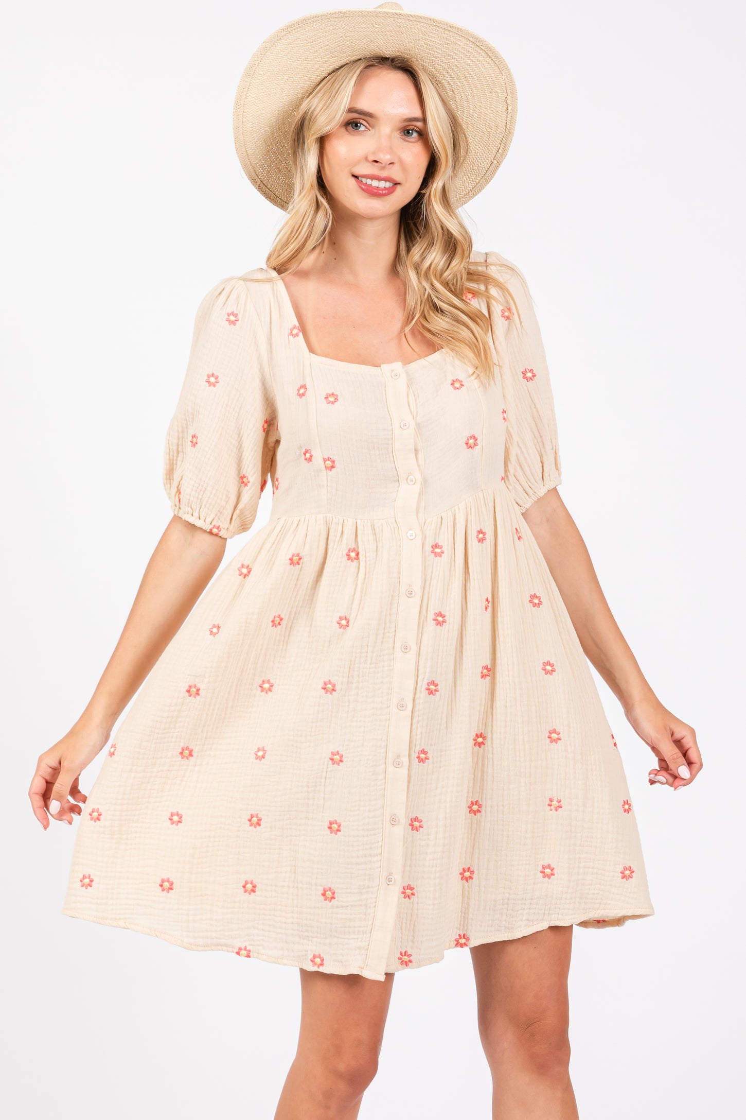 woman wearing a beige puff sleeve floral print dress with a square neckline and buttons down the front