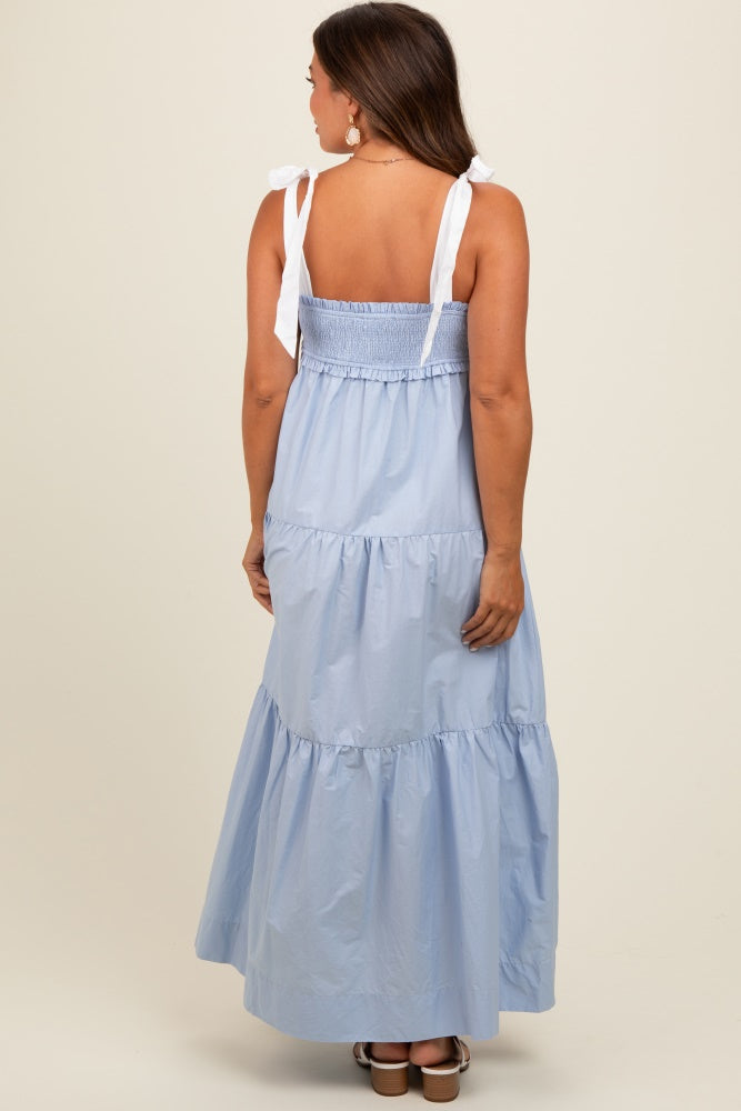 woman wearing a light blue maternity maxi dress with adjustable ties and tiered skirt, showing her baby bump from the back