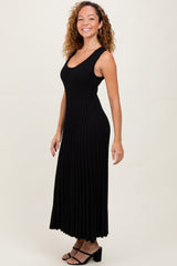 woman wearing a black ribbed maxi dress with a sleeveless design and a fitted silhouette