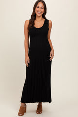 woman wearing a black ribbed maxi maternity dress with a fitted silhouette and sleeveless design