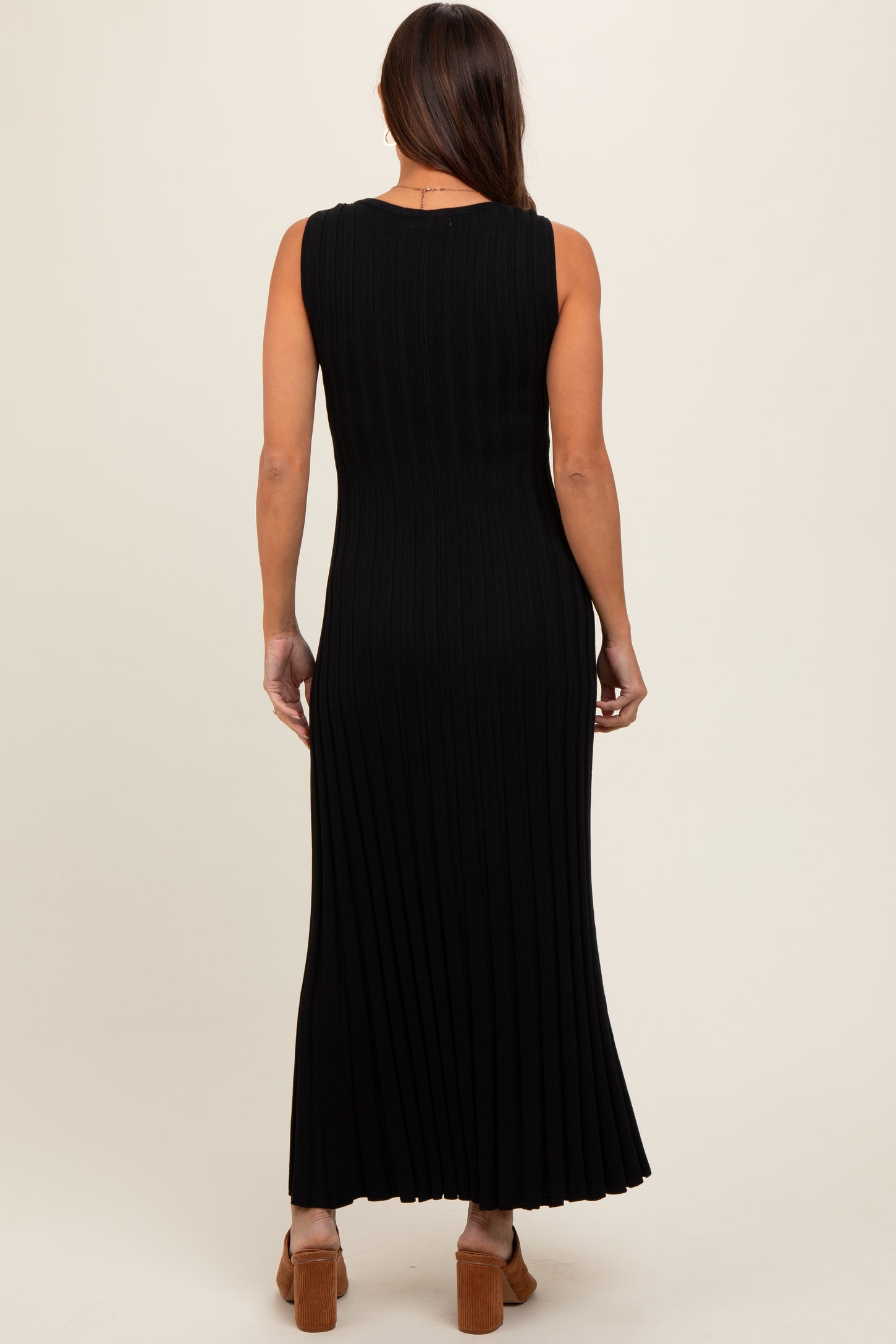 woman wearing a black ribbed maxi dress with a fitted silhouette and pleated details in a maternity style