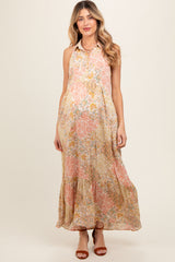 woman wearing a floral print sleeveless maternity maxi dress with a tiered skirt and a button-down collar